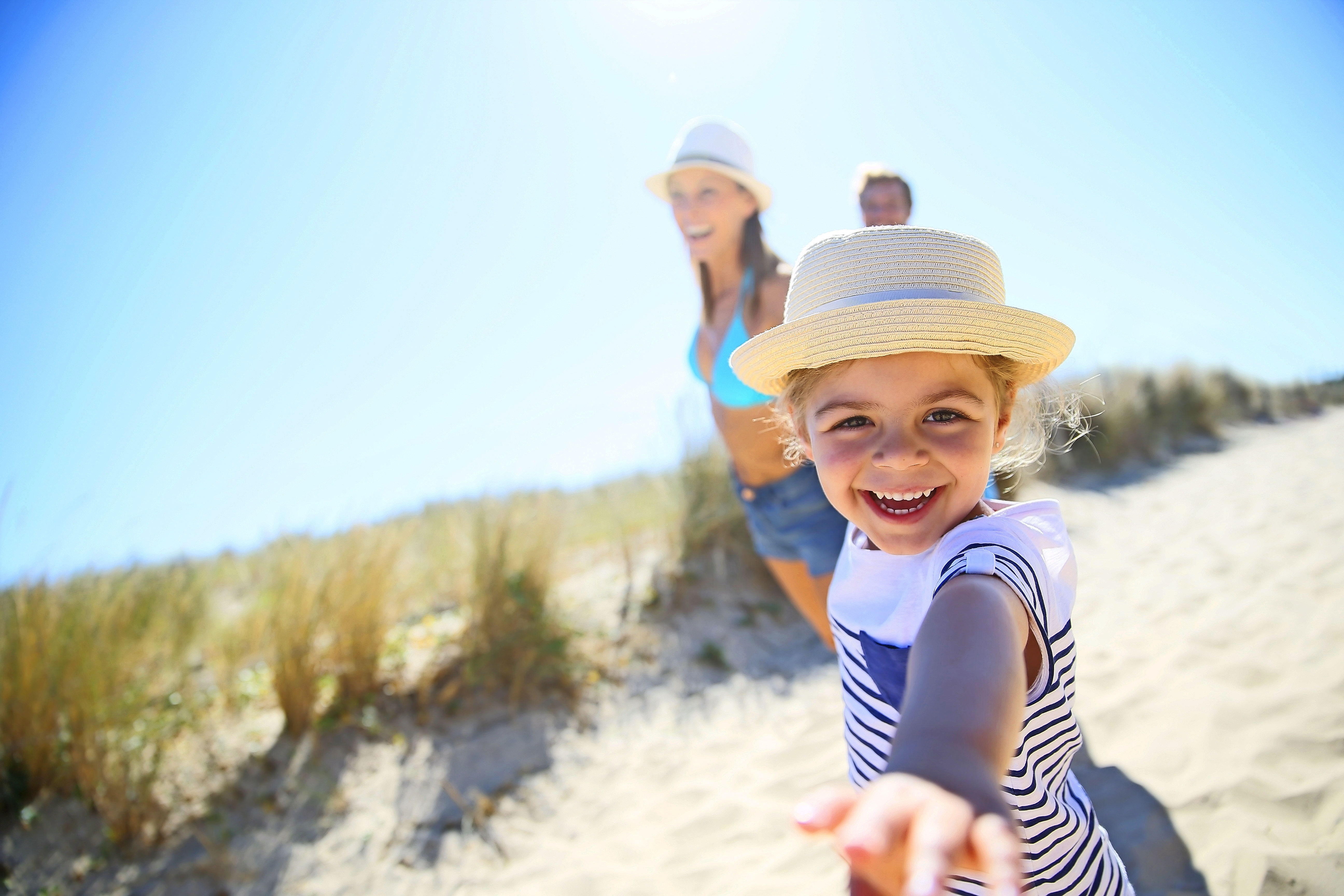 Kleines Mädchen, Eltern Arme ziehen zum Strand zu laufen