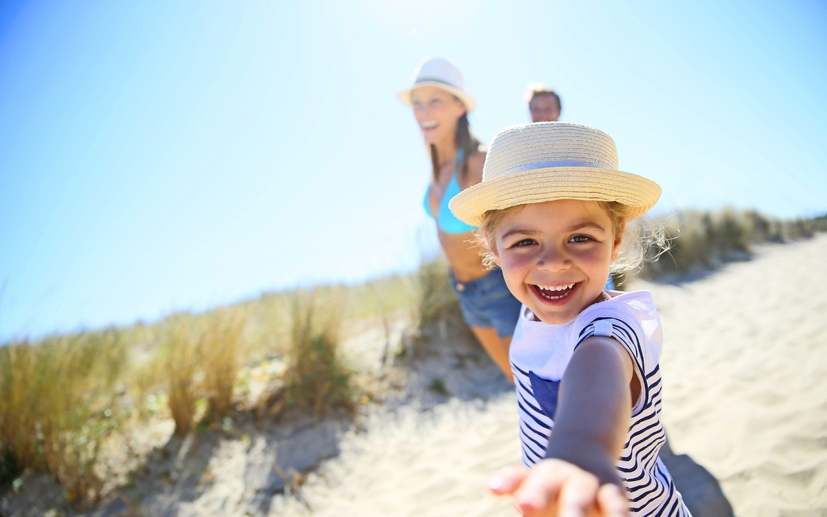 Kleines Mädchen, Eltern Arme ziehen zum Strand zu laufen